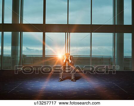 Stressed Businessman working late in office as the sunsets View Large Photo Image Stock Photo - Stressed Businessman working late in office as the sunsets. Fotosearch