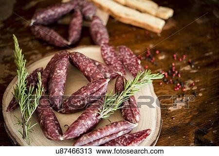 Stock Image - Strings of sausages, rosemary, peppercorn. Fotosearch