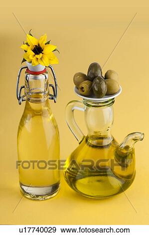Sunflower plant with a jug of olive oil View Large Photo Image Stock Photo - Sunflower plant with a jug of olive oil. Fotosearch