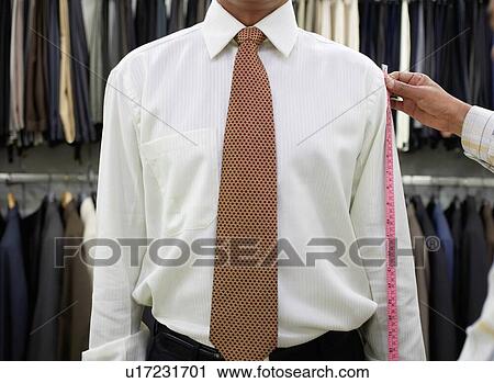 Stock Image - Tailor measuring business man for suit. Fotosearch