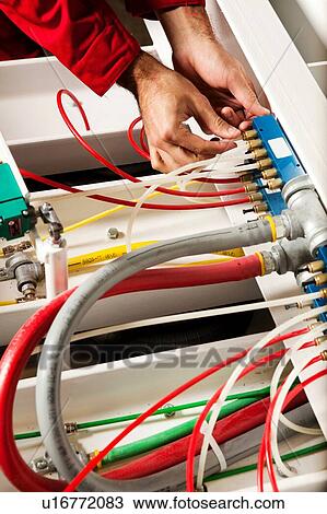 Stock Image - Technician fixing cabling and wiring circuit. Fotosearch