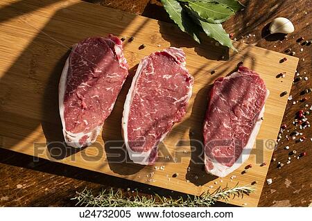 Thick slices of raw meat, rosemary, peppercorn View Large Photo Image Stock Photography - Thick slices of raw meat, rosemary, peppercorn. Fotosearch