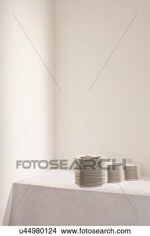 Picture - Three stacks of plates and cutlery on table. Fotosearch