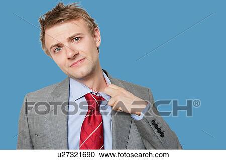 Tired young businessman loosening tie View Large Photo Image Stock Image - Tired young businessman loosening tie. Fotosearch