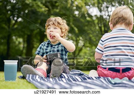 Toddler eating in park View Large Photo Image Stock Image - Toddler eating in park. Fotosearch
