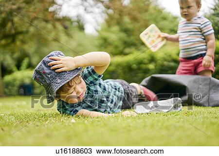Toddler falling on grass in park View Large Photo Image Stock Image - Toddler falling on grass in park. Fotosearch