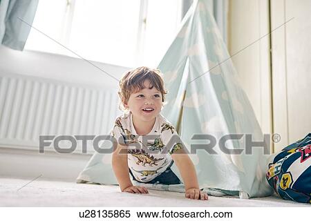 Stock Photography - Toddler playing in a teepee in his bedroom at home. Fotosearch