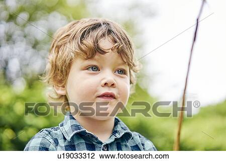 Stock Image - Toddler playing with stick in park. Fotosearch