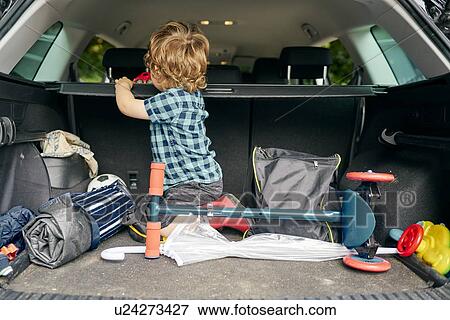 Toddler playing with toy car in back of vehicle View Large Photo Image Stock Photo - Toddler playing with toy car in back of vehicle. Fotosearch