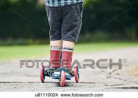 Toddler riding on push scooter in park View Large Photo Image Picture - Toddler riding on push scooter in park. Fotosearch