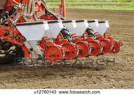 Stock Image - Tractor with mounted crop seeder. Fotosearch