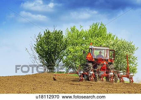 Stock Image - Tractor with mounted crop seeder. Fotosearch