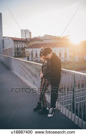 Stock Image - Trendy couple hugging on bridge, Milan, Italy. Fotosearch