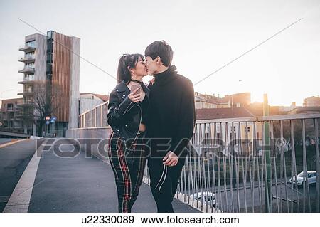 Stock Photo - Trendy couple kissing on bridge, Milan, Italy. Fotosearch