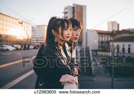 Stock Photography - Trendy couple looking over bridge, Milan, Italy. Fotosearch