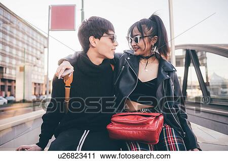 Trendy couple sitting on concrete structure smiling at each other, Milan, Italy View Large Photo Image Stock Image - Trendy couple sitting on concrete structure smiling at each other, Milan, Italy. Fotosearch