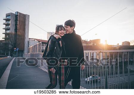 Trendy couple walking over bridge, Milan, Italy View Large Photo Image Stock Photography - Trendy couple walking over bridge, Milan, Italy. Fotosearch