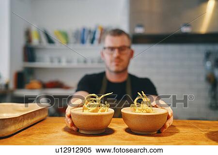 Waiter placing food on service counter in restaurant View Large Photo Image Stock Photography - Waiter placing food on service counter in restaurant. Fotosearch