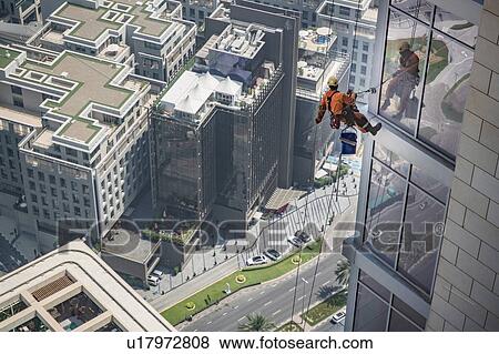 Stock Photo - Window cleaner working on office building walls, Dubai, UAE. Fotosearch