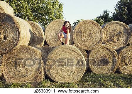 Woman climbing onto bale of hay, Wilhelminenberg, Vienna, Austria View Large Photo Image Stock Image - Woman climbing onto bale of hay, Wilhelminenberg, Vienna, Austria. Fotosearch
