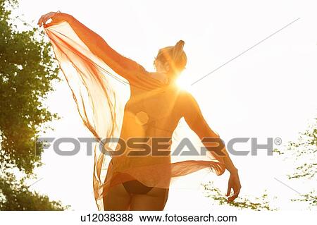 Woman dancing in park with strong sunshine View Large Photo Image Stock Photo - Woman dancing in park with strong sunshine. Fotosearch