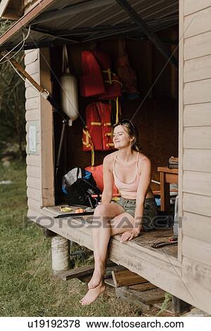 Stock Photo - Woman enjoying moment in hut. Fotosearch