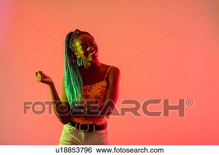 Woman folding arm, posing against peach background View Large Photo Image Stock Photograph - Woman folding arm, posing against peach background. Fotosearch