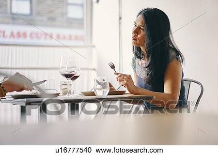 Stock Image - Woman having meal in restaurant. Fotosearch