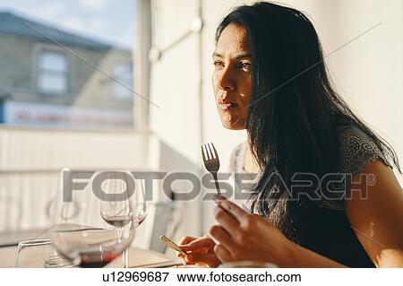 Woman having meal in restaurant View Large Photo Image Stock Photo - Woman having meal in restaurant. Fotosearch
