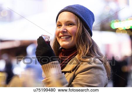 Woman holding small glass of beverage, Christmas Market, Freiburg, Deutschland View Large Photo Image Stock Image - Woman holding small glass of beverage, Christmas Market, Freiburg, Deutschland. Fotosearch