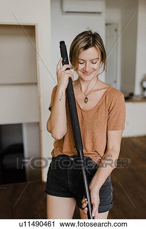 Woman holding stick in new home View Large Photo Image Stock Image - Woman holding stick in new home. Fotosearch