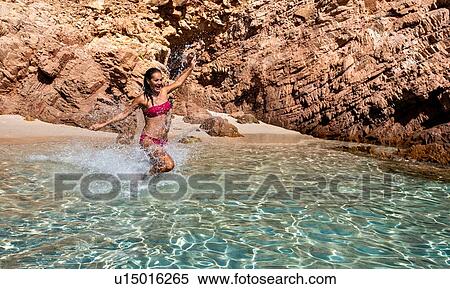 Woman in bikini enjoying clear sea water in lagoon, La Maddalena island, Sardegna, Italy View Large Photo Image Stock Photography - Woman in bikini enjoying clear sea water in lagoon, La Maddalena island, Sardegna, Italy. Fotosearch