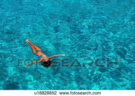 Woman in bikini enjoying clear sea water View Large Photo Image Stock Image - Woman in bikini enjoying clear sea water. Fotosearch