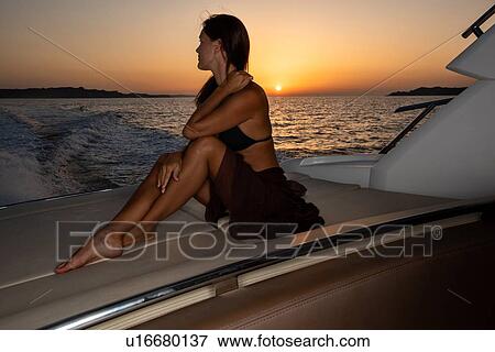 Woman in bikini relaxing on yacht at sunset View Large Photo Image Stock Photo - Woman in bikini relaxing on yacht at sunset. Fotosearch
