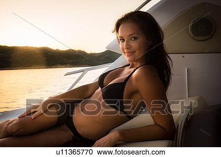 Woman in bikini relaxing on yacht View Large Photo Image Stock Image - Woman in bikini relaxing on yacht. Fotosearch