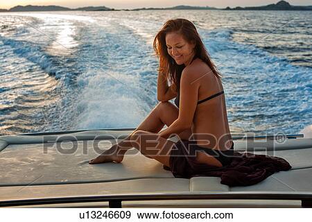 Stock Photo - Woman in bikini relaxing on yacht. Fotosearch