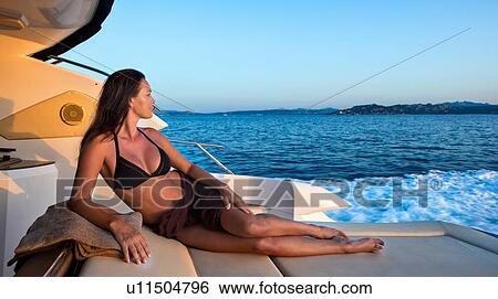 Stock Photograph - Woman in bikini relaxing on yacht. Fotosearch