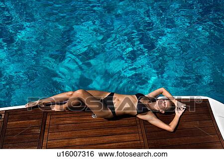Woman in bikini relaxing on yacht View Large Photo Image Stock Photograph - Woman in bikini relaxing on yacht. Fotosearch