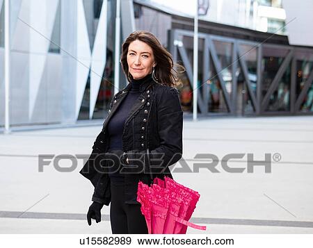 Woman in black suit walking in city View Large Photo Image Stock Photo - Woman in black suit walking in city. Fotosearch