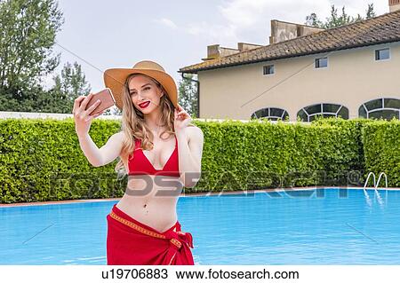 Woman in red bikini taking selfie by swimming pool View Large Photo Image Stock Image - Woman in red bikini taking selfie by swimming pool. Fotosearch
