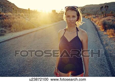 Woman on country road at sunset, Joshua Tree, California, USA View Large Photo Image Stock Image - Woman on country road at sunset, Joshua Tree, California, USA. Fotosearch