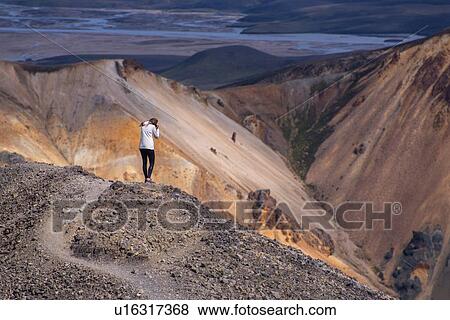 Woman photographing from ridge of hill, Landmannalaugar, Iceland View Large Photo Image Stock Photo - Woman photographing from ridge of hill, Landmannalaugar, Iceland. Fotosearch
