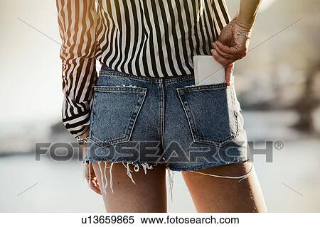 Woman placing smartphone into pocket View Large Photo Image Stock Photography - Woman placing smartphone into pocket. Fotosearch