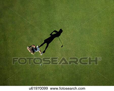 Stock Photo - Woman playing golf on golf course. Fotosearch