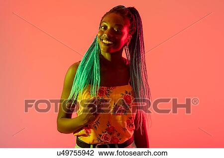Stock Image - Woman posing against peach background. Fotosearch