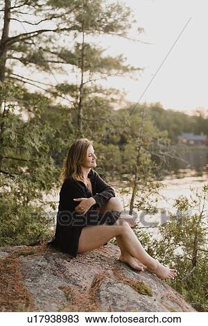 Woman relaxing on boulder by lake, Bobcaygeon, Ontario, Canada View Large Photo Image Stock Image - Woman relaxing on boulder by lake, Bobcaygeon, Ontario, Canada. Fotosearch