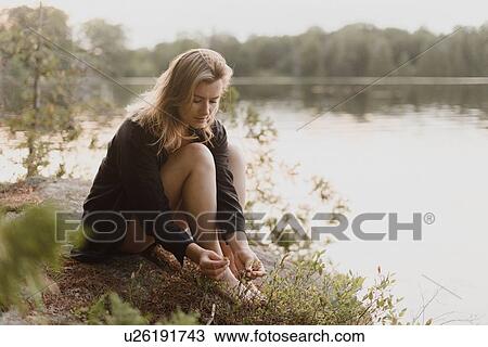 Woman relaxing on boulder by lake, Bobcaygeon, Ontario, Canada View Large Photo Image Stock Image - Woman relaxing on boulder by lake, Bobcaygeon, Ontario, Canada. Fotosearch