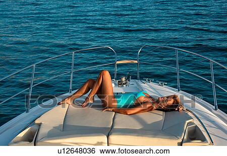 Stock Photograph - Woman relaxing on yacht. Fotosearch