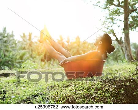 Woman sitting in bucket to cool off from hot day View Large Photo Image Stock Image - Woman sitting in bucket to cool off from hot day. Fotosearch