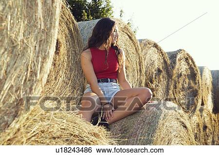 Stock Photograph - Woman sitting on bale of hay, Wilhelminenberg, Vienna, Austria. Fotosearch